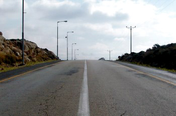 כביש עולה לקראת רכס גבעה עם שדה ראייה חסום, סכנת רכב מהכיוון הנגדי.