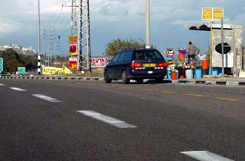 רכב חונה ליד תחנת אוטובוס עם דוכן פרחים התופס חלק מהמפרץ.